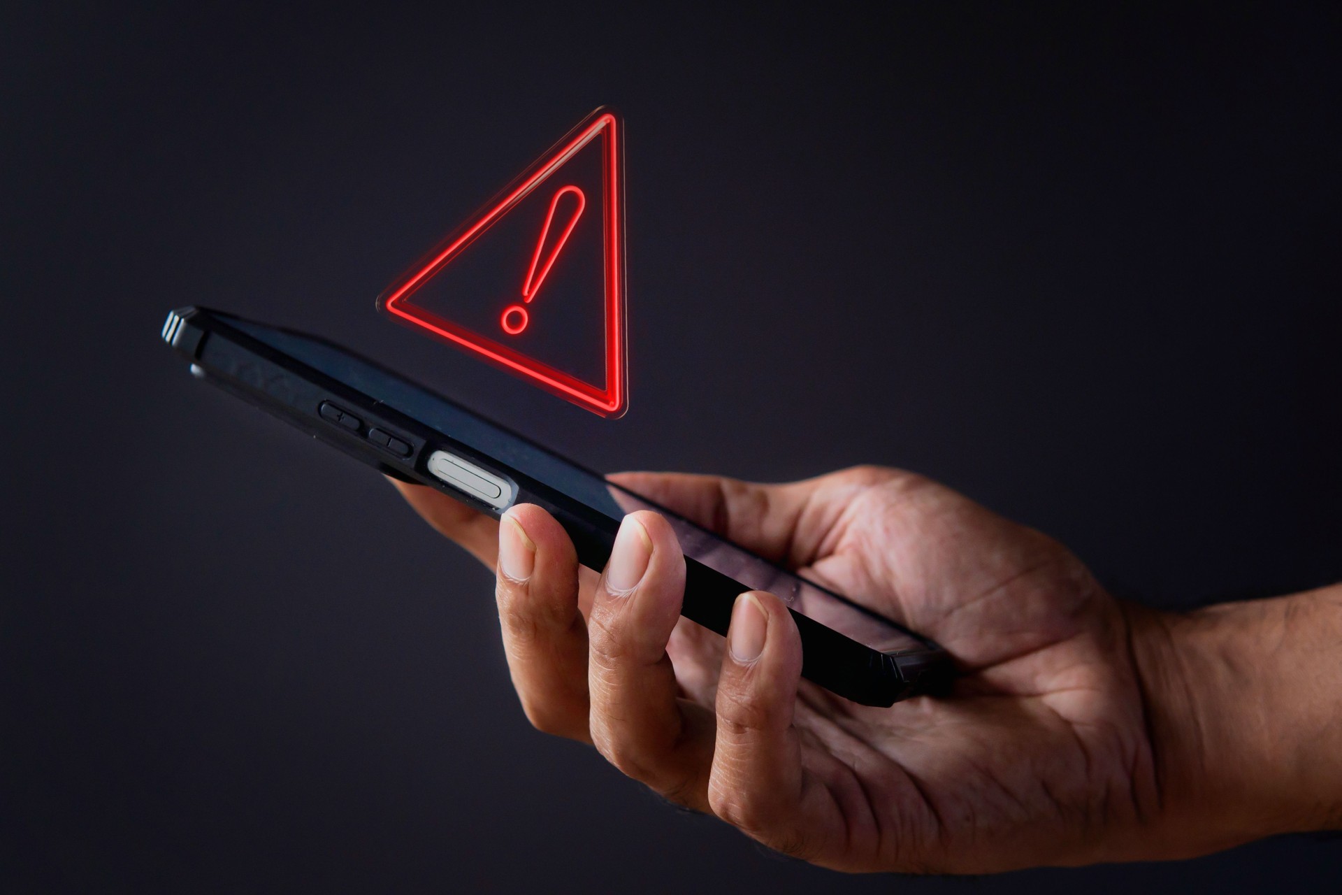 Smartphone with triangle caution warning icon.